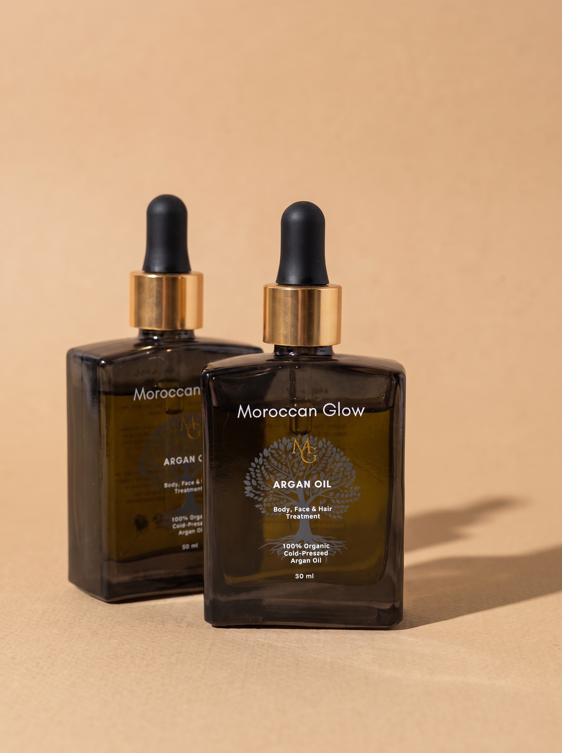 Zwei Flaschen Moroccan Glow Arganöl à 50 ml aus Braunglas mit goldenem Ring und schwarzer Pipette