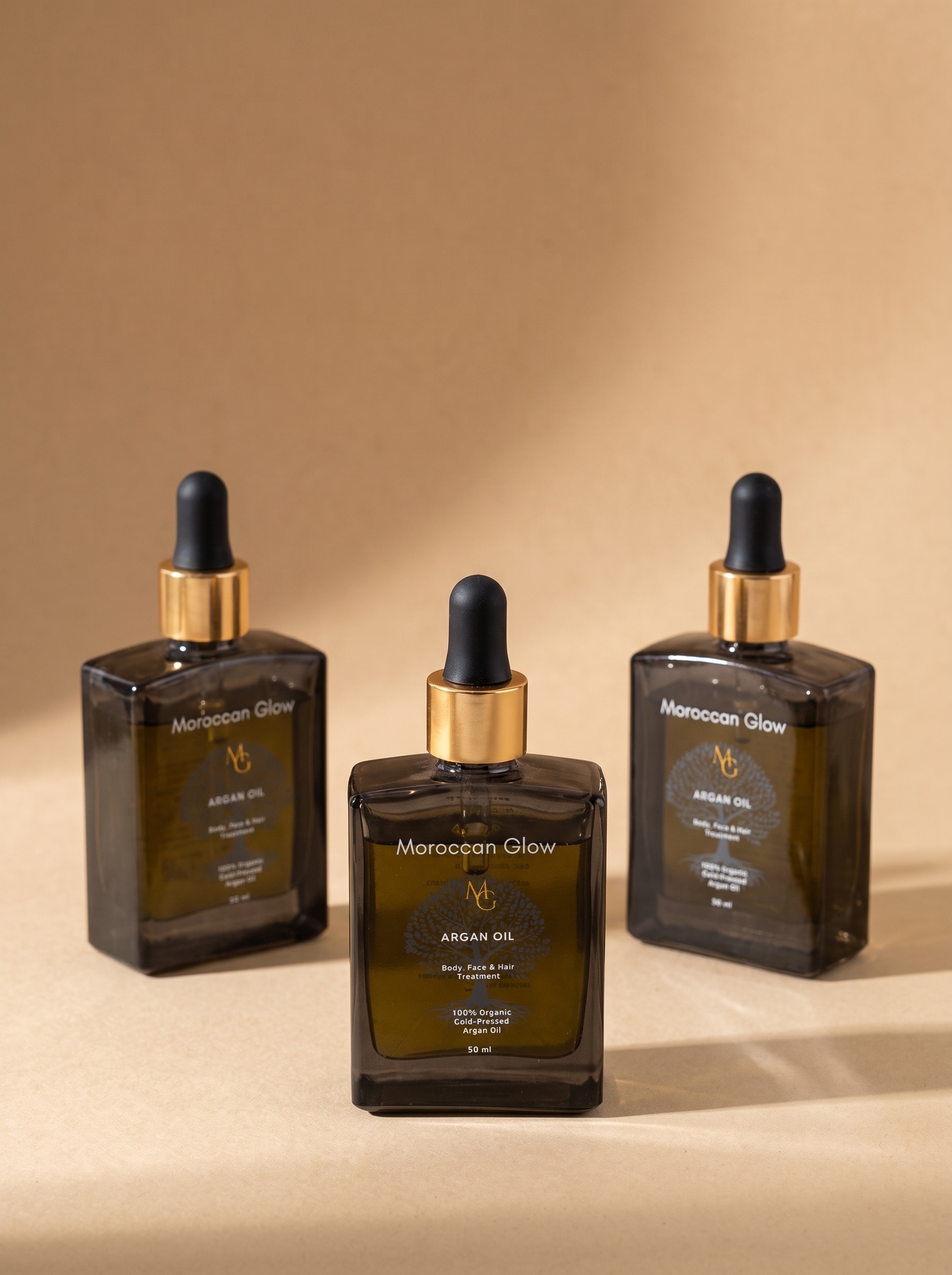 Drei Flaschen Moroccan Glow Arganöl à 50 ml aus Braunglas mit goldenem Ring und schwarzer Pipette